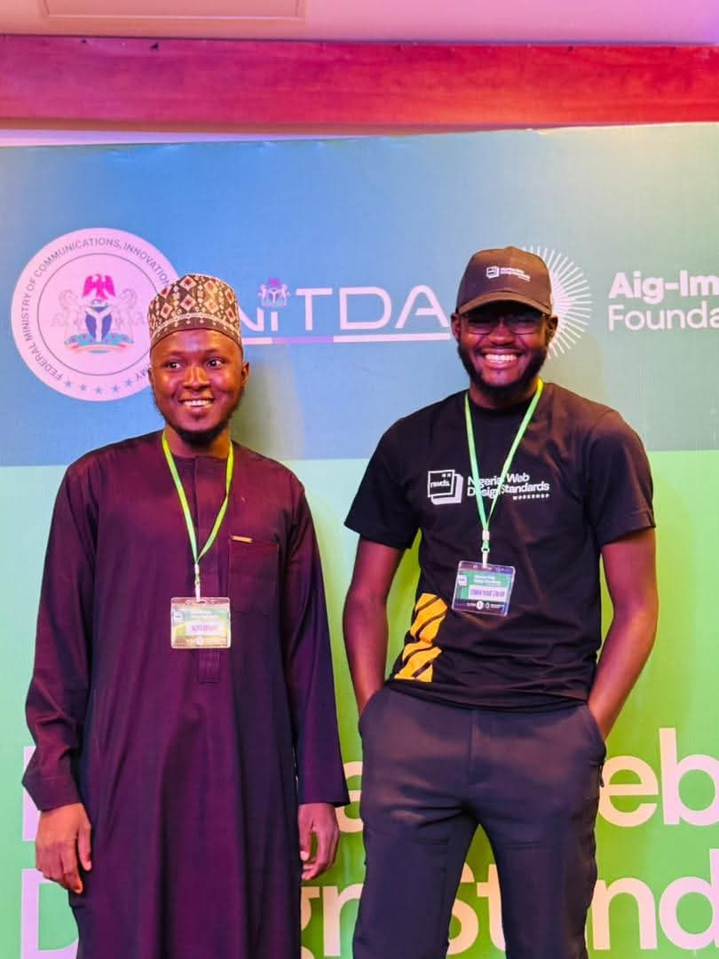 Aliyu Usman with another participant in front of the event backdrop