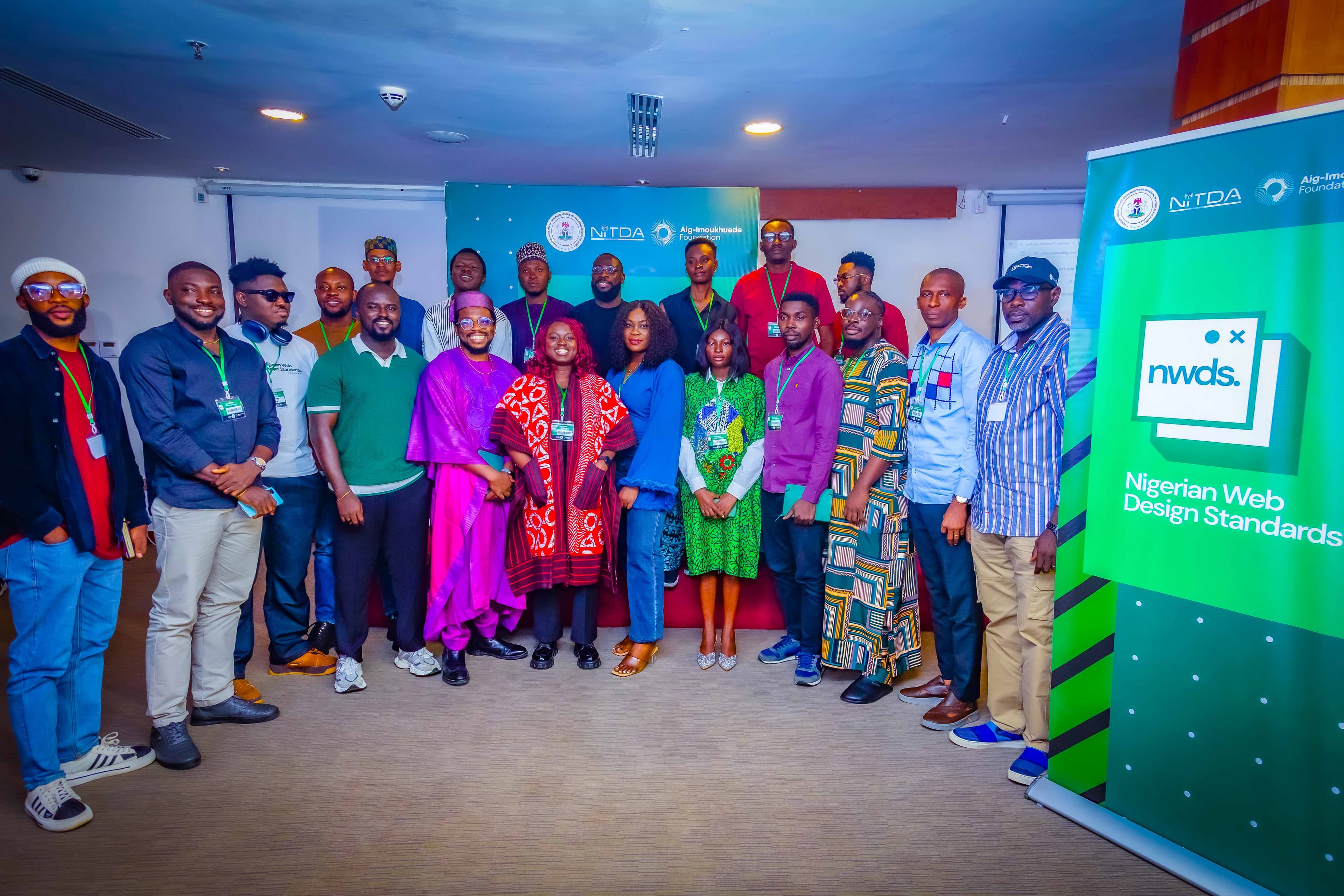 Workshop participants in a group photo beside the Nigerian Web Design Standards banner